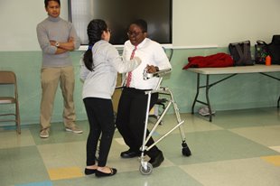 Student with a walking assistance device dancing with another student.